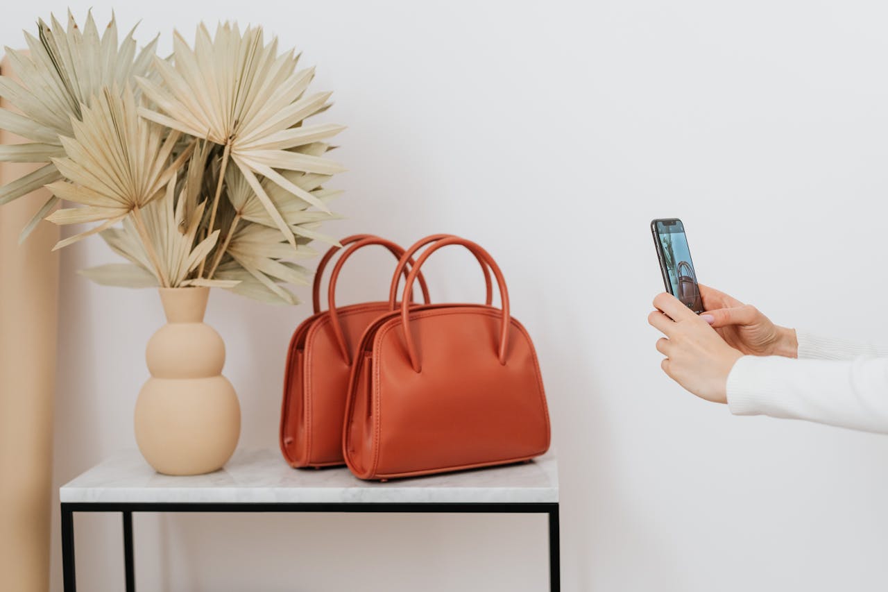 Two elegant leather bags next to a decorative vase, photographed.